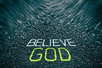 Believe God Chalk Drawings on Asphalt Ground with Motion Blur, Suitable for Religion Concept.