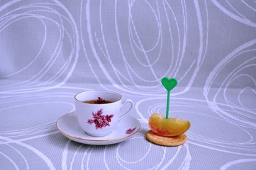 cup of tea with cookies, caramel, candy on an abstract gray background