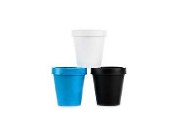 White, black and blue plastic cups isolated on white