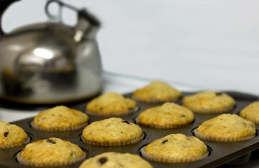 Fresh baked muffins with kettle on stove top