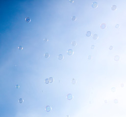 Soap bubbles fly in the blue sky