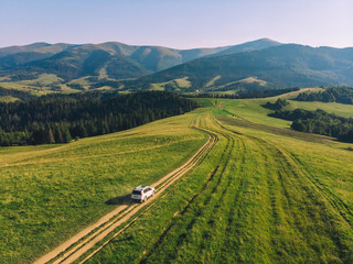 white suv car in mountains at path trail on sunset © phpetrunina14