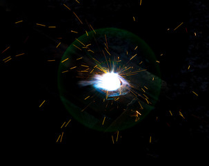 Sparks from welding at a construction site as a background