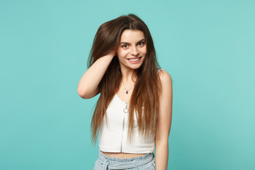 Portrait of smiling young woman in light casual clothes looking camera, putting hand on head...