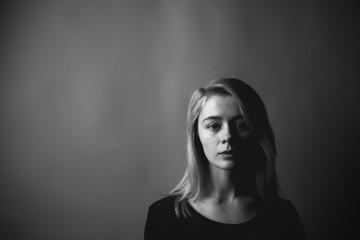 Fototapeta premium Portrait of the sad young woman on gray background. Black and white