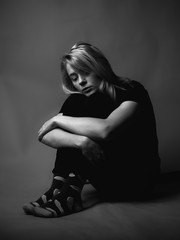 Sad young woman sitting on the floor