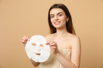 Close up brunette half naked woman 20s with perfect skin, nude make up isolated on beige pastel...
