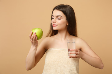 Close up half naked woman 20s with perfect skin, nude make up hold apple, water isolated on beige...