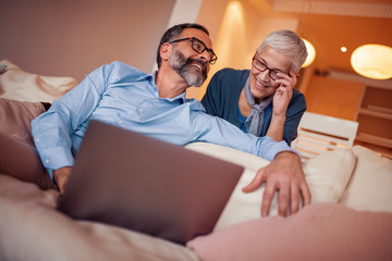 Senior couple working with laptop at home