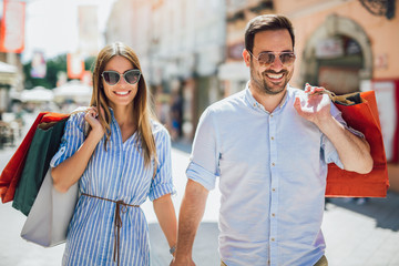 Beautiful young couple enjoying in shopping, having fun in the city