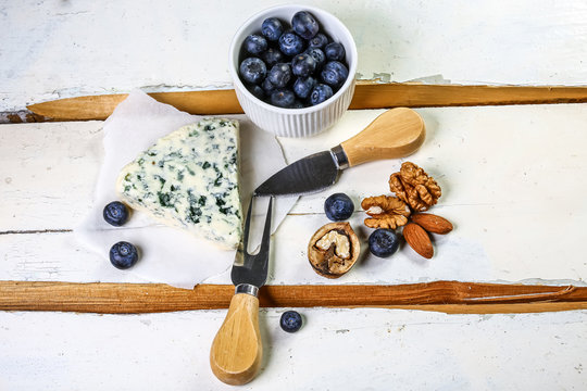 Danish blue cheese on a wooden board. blue cheese with mild berries - Powered by Adobe