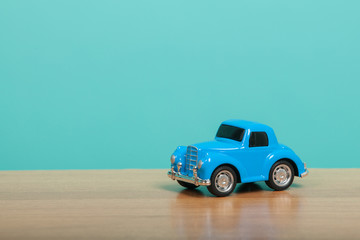 Fototapeta na wymiar Cute blue toy car on green background. Travel concept