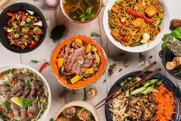 Asian food background with various ingredients on rustic wooden table.