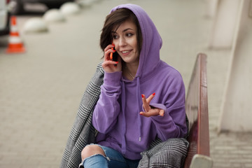 Stylish modern girl emotionally talking on the smartphone. Beautiful young woman talking...