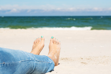 Legs of a woman on a sandy beach