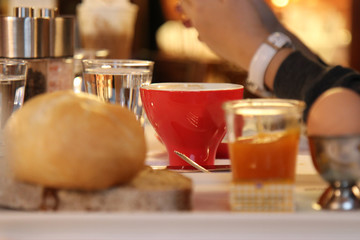 red coffee cup on table in blurred. Red espresso cup on office desk.