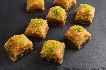 Pistachio baklava on a black plate. Dessert.