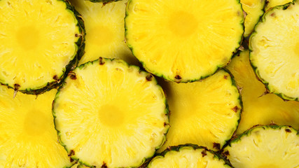 Pineapple juicy yellow slices background. Top view.