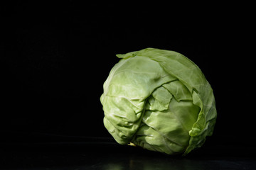 head of cabbage on a black background. Concept - cabbage diet