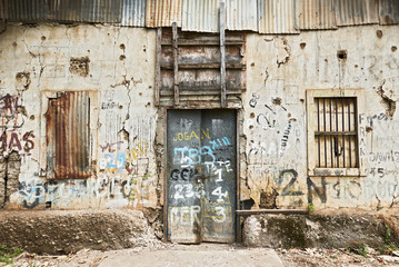 Fototapeta na wymiar Close-up view of the front of an abandoned ruined building, windows and door closed, Puerto Princesa City, Palawan, Philippines