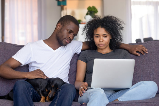 Serious African American Man And Woman Using Laptop At Home