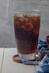 close up of iced cola in glass on the table