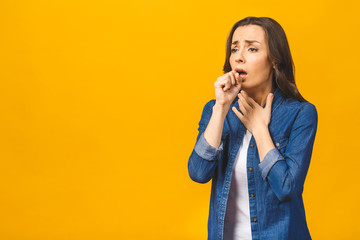 Closeup portrait of cute sick young woman having sore throat isolated, holding hand on her...