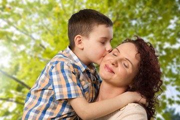Happy smiling family with daughter over green trees background
