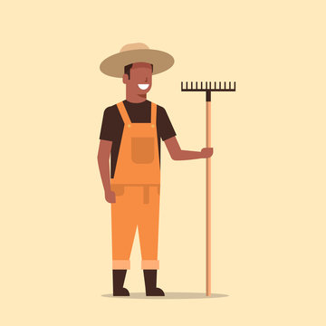 gardener holding rake african american country man working in garden gardening eco farming concept full length