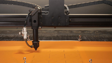 In an industrial garment factory, a special Laser Cutting Fabric cuts out certain textile pieces. Concept of: Laser machine, Crosses, Work in a factory, Automatic cutting.