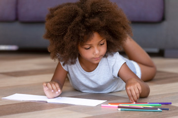 African American little girl playing, drawing with colored pencils