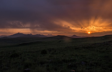 Sunrise landscape with mountains, clouds, orange sky and sun beams, Lesotho, Africa
