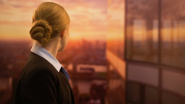 Young business employee looking at sunset, dreaming of successful job career