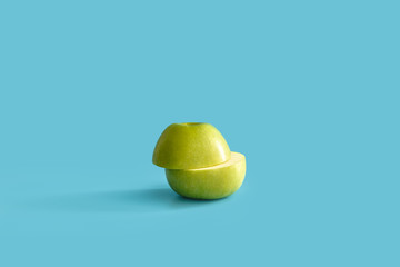 Juicy green sliced apple on blue pastel background. Minimal concept.