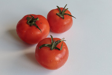 Water drops on a fresh ripe tomatoes. Vegan food.