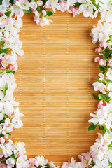 Frame of spring flowers of sakura on bamboo background. Beautiful cherry blossom sakura in springtime