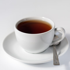 White cup of tea on a white background. Minimal composition. Tea party concept, break.