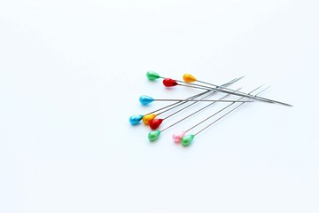 sewing pins with colored heads on a white background