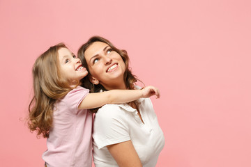 Woman in light clothes have fun with cute child baby girl. Mother, little kid daughter isolated on pastel pink wall background, studio portrait. Mother's Day, love family, parenthood childhood concept