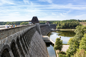 Blick auf die Talsperre entlang der Sperrmauer von Oben, seitlich der Promenade