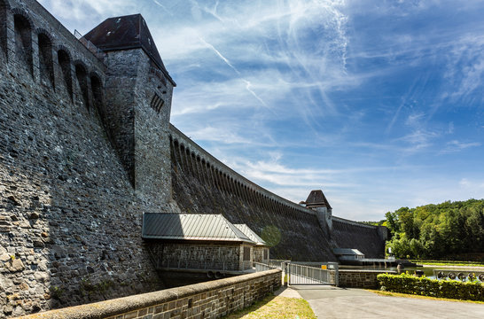 Sicht auf das riesige Mauerwerk der Talsperre, die sich von links nach rechts erstreckt