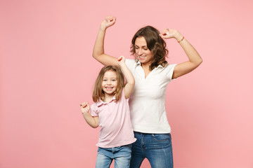 Woman in light clothes have fun with cute child baby girl. Mother, little kid daughter isolated on pastel pink wall background, studio portrait. Mother's Day, love family, parenthood childhood concept