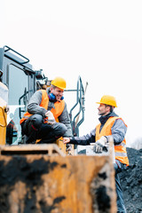 Foreman showing worker in open-cast mining pit direction