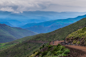 Fototapeta na wymiar Eternal mountain view with road and basotho man riding a basotho pony, Lesotho, Africa