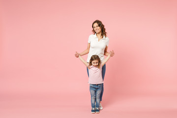 Woman in light clothes have fun with cute child baby girl. Mother, little kid daughter isolated on pastel pink wall background, studio portrait. Mother's Day, love family, parenthood childhood concept