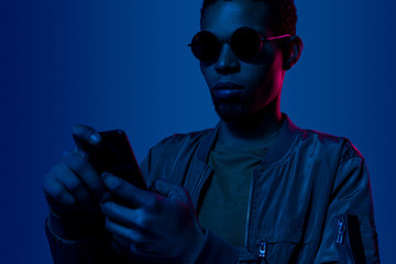 Young african man using mobile phone in the night