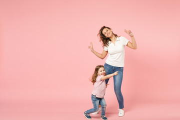 Fototapeta na wymiar Woman in light clothes have fun with cute child baby girl. Mother, little kid daughter isolated on pastel pink wall background, studio portrait. Mother's Day, love family, parenthood childhood concept