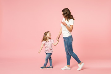Woman in light clothes have fun with cute child baby girl. Mother, little kid daughter isolated on...