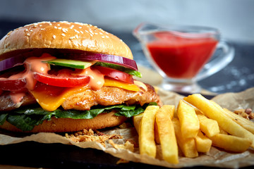 Delicious burgers with beef, tomato, cheese and french fries with tomato sauce