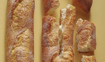 Fresh french baguette bread on yellow background.